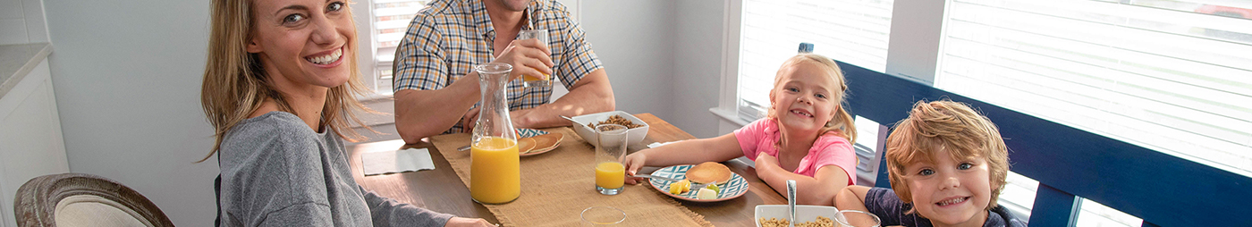 family eating breakfast with orange juice