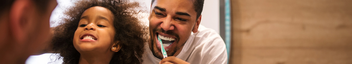 father and daughter brushing teeth